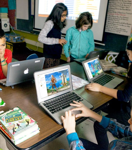 Grupo de alumnos trabajando en ordenadores portátiles con su perfil de avatar Classcraft en la pantalla