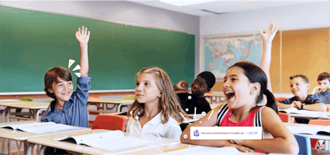 Enseignant souriant et élèves travaillant avec des tablettes dans une salle de classe